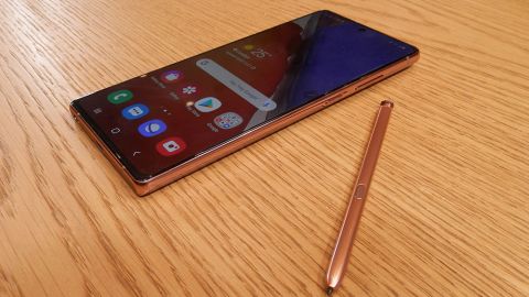 Samsung Galaxy Note 20 dengan S Pen diletakkan di atas sebuah meja kayu
